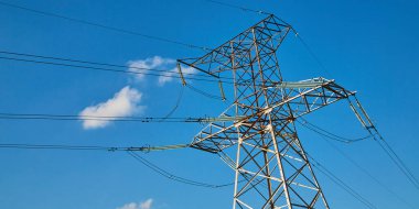 Elektrik santrali. Elektrik iletim kulesi. Yüksek voltaj direği. Dağıtım jeneratörü. Enerji. Parlak mavi gökyüzü