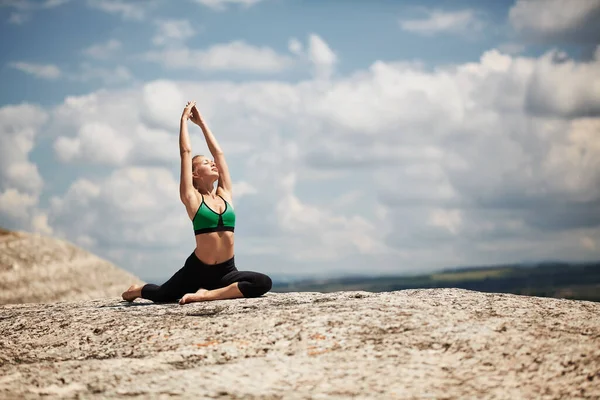 Deportes al aire libre. Entrenamiento matutino. Entrenamiento físico. Mujer haciendo ejercicio de estiramiento. Paisaje pintoresco sobre fondo — Foto de Stock