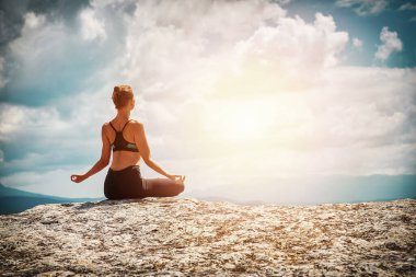 Yoga zamanı ve meditasyon. Pilates. Esniyorum. Şık giyinmiş bir kadın. Doğada meditasyon yapan bayan..