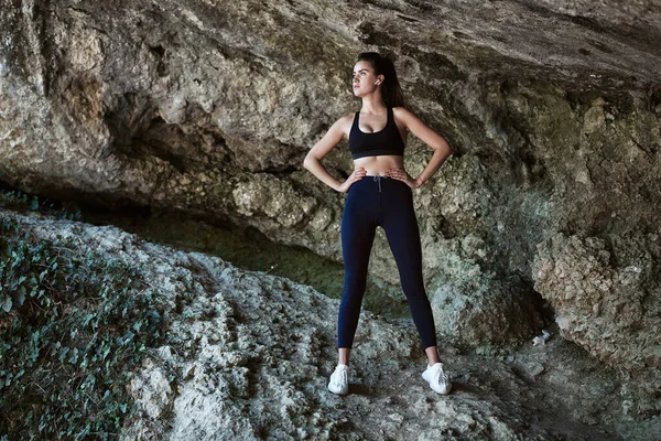 Mujer deportiva posando cerca de la montaña. Entrenamiento deportivo al aire libre. Entrenamiento físico. Mañana corriendo. concepto de estilo de vida saludable — Foto de Stock