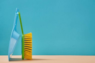 Temizlik. Oda servisi. Saflık. Temizlik malzemeleri. Mavi arka planda yalıtılmış mala ve fırça. Metin için alanı kopyala
