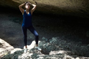 Dağlarda poz veren terli bir kadın. Rahat spor giyim. Spor ve spor. Fiziksel aktivite. Açık havada idman. Boşluğu kopyala