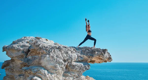 Jógaidő, elmélkedés vagy sportos életmód koncepció. Női edzés rugalmasság a fehér éles sziklán. Óceáni táj. — Stock Fotó