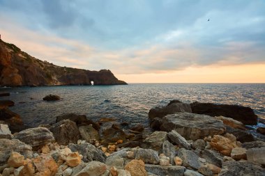 Çıplaklar plajı ya da bakire doğası. Yaz manzarası. Güzel dağlarda gün batımı. Sakinleştirici berrak su.