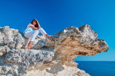 Dışarıda poz veren güzel bir kadın. Doğa manzarası. Modellik ya da rahatlama fikri. Deniz Burnu ya da Bulutsuz Gökyüzü.