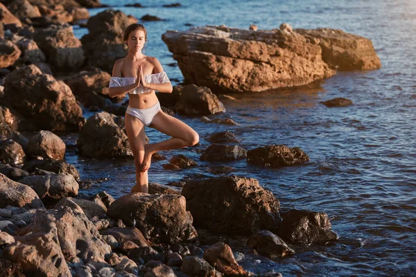 Vrouw balanceert op één been. Yoga tijd, Eenzaamheid, meditatie en contemplatie concept. Zeezicht. Kopieerruimte — Stockfoto