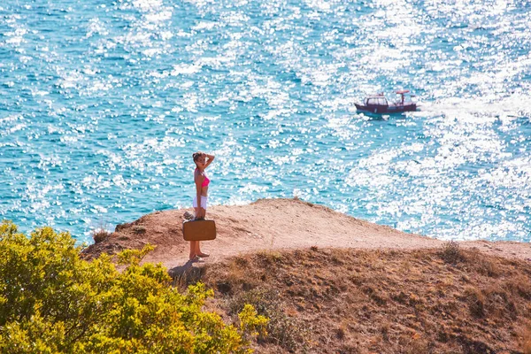 Femme errant avec valise sur le sentier de montagne. Passion pour le voyage. L'été et les vacances. Mer brillante, espace de copie — Photo