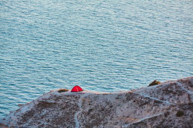 Dağda çadır, deniz manzaralı. Yüksek kayalıklarda yol. Aktif yaşam tarzı ve macera konsepti. Kamp ve seyahat fikri