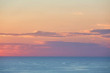 Güzel bir akşam gökyüzü ve panoramik manzara. Altın saat ve sakin deniz. Bakire doğa ve okyanus manzarası konsepti, kopyalama alanı