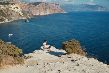 Serbest meslek kavramı. Bayan tatilden sonra dizüstü bilgisayarda çalışıyor. Doğa manzarası ve temiz hava. Uzak ofis ve seyahat zaman fikri