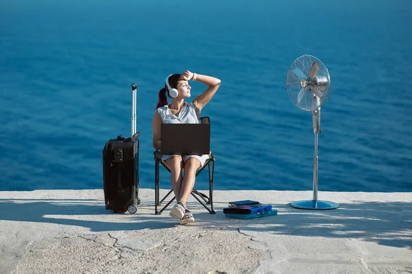 Életmódváltási ötlet. Üzleti utazási koncepció. Boldog nő headset dolgozik laptop, látnivaló a háttérben. — Stock Fotó