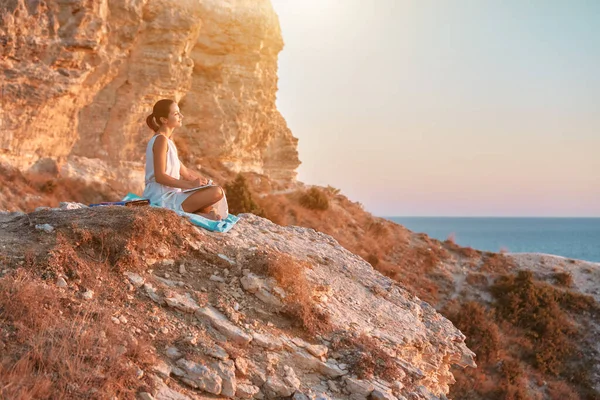 Uçurumdaki kadın manzaranın tadını çıkarıyor ve deftere yazı yazıyor. Düşünce doğası ve günlük tutma kavramı, kopyalama alanı