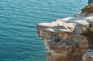 Keskin uçurum ve derin mavi deniz. Yüksek dağda yalnızlık için bir yer. Bakire doğa ve temiz hava konsepti, kopyalama alanı