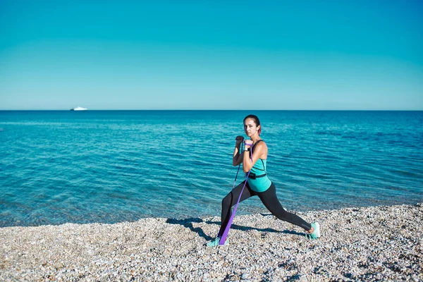 Señora haciendo ejercicio con bandas elásticas. Ropa deportiva cómoda para la aptitud. Estilo de vida activo y concepto deportivo, espacio de copia — Foto de Stock