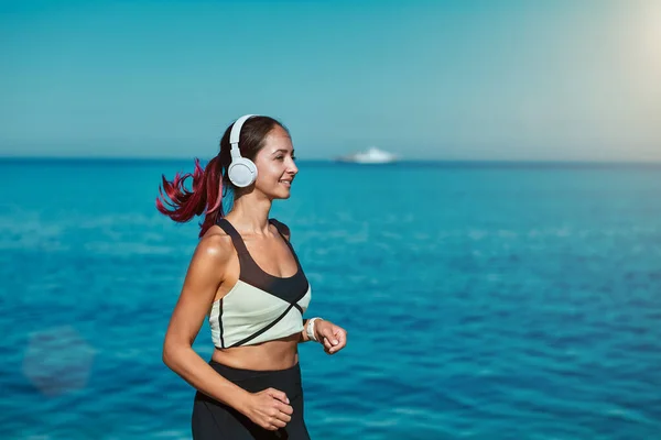 Una mujer corriendo por el océano. Aire fresco y naturaleza virgen vista. Deporte activo tiempo fitness y estilo de vida saludable concepto — Foto de Stock