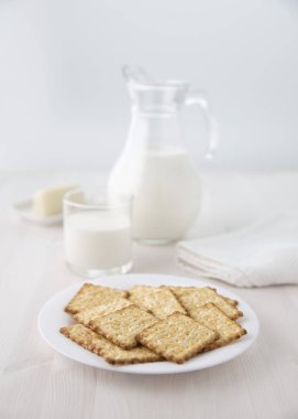 Kırık bir cam şişe süt ve bir cam ve peynir küçük tabakta seçici odak ile beyaz tabakta. Bulanıklık