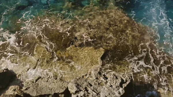 Man staat aan de rand van de afgrond en kijkt naar de zee. Voorraad. Man reiziger op zoek naar avontuur — Stockfoto