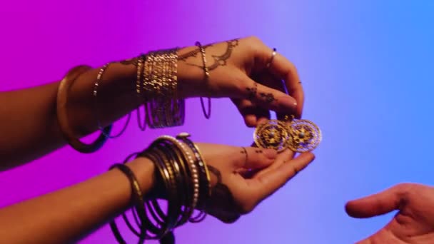 Індійська жінка з сережки в руці. Фондовий. Жінка дає людині її ювелірні вироби, подарунок, як знак дружби — стокове відео