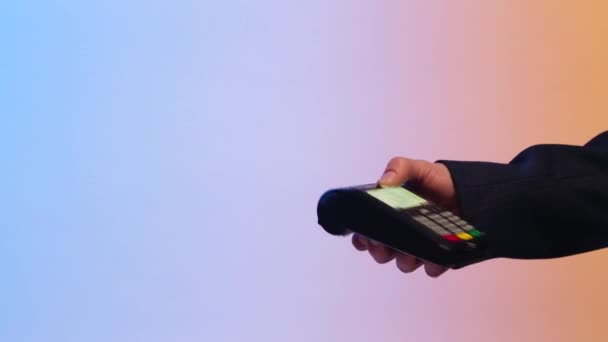Close up van klant betalen per creditcard. Voorraad. Betaling voor de aankoop via overschrijving op een gekleurde achtergrond — Stockvideo