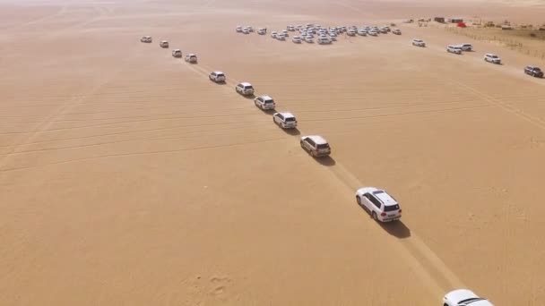 4x4 SUV coches que conducen a través de las dunas de arena en el desierto de Abu Dhabi. Acciones. Vista superior de SUV en el desierto — Vídeo de stock