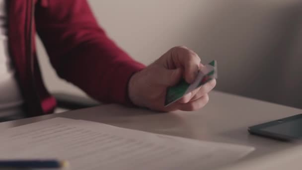 Концепція онлайн платежів. Запас. Бізнесмен тримає кредитну картку в руці, використовуючи або вводячи ідентифікаційні номери після покупки товарів у магазинах роздрібної торгівлі через Інтернет — стокове відео