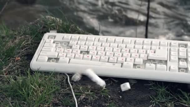 Hammer quebra um teclado de computador. Teclado de computador quebrado na natureza. O conceito de tecnologias tem um impacto negativo no mundo — Vídeo de Stock