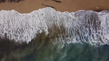 Kum plaj. Hisse senedi. Mavi dalgalar kıyıya haddeleme ile güzel bir kumsalı üstten görünüm. Deniz arka plan