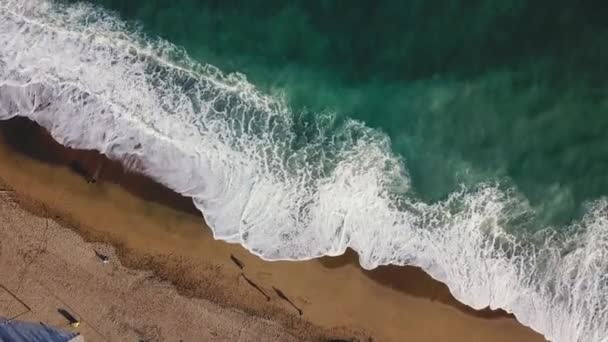 Spiaggia di sabbia. Azioni. Vista dall'alto di una bellissima spiaggia sabbiosa con le onde blu che rotolano sulla riva. Fondo marino — Video Stock