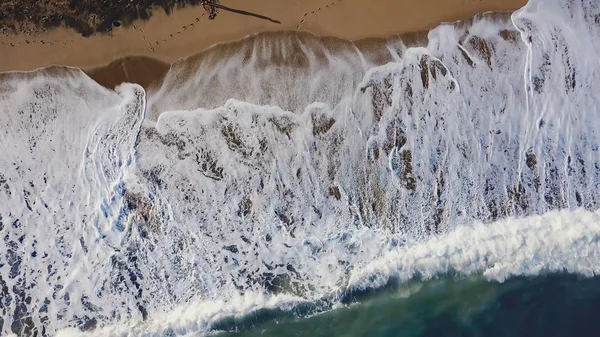 Praia de areia. Estoque. Vista superior de uma bela praia de areia com as ondas azuis rolando para a costa. Fundo marinho — Fotografia de Stock