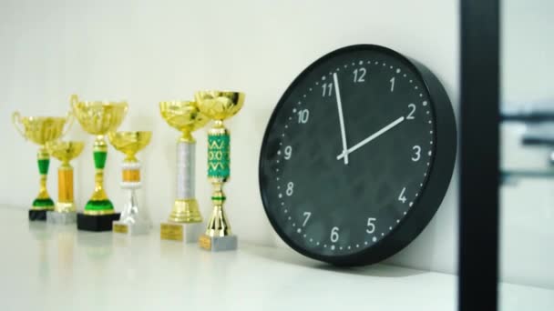 Premio trofeo para la exposición ganadora en el estante. Acciones. Reloj y trofeos en el estante. El concepto de tiempo y deportes — Vídeos de Stock