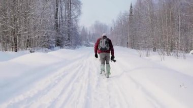Seyahat ve kış sezonu orman yolu boyunca yürüyüş. Küçük. Ormanda holding kamera - macera, trekking ve mevsimlik tatil turist izinde dikiz ile kavramı içinde yürüyen genç adam
