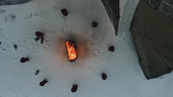 山の火災でフード付きのグループ。映像。冬の山で犠牲のシーン。添加の犠牲の宗教的な儀式 — ストック動画