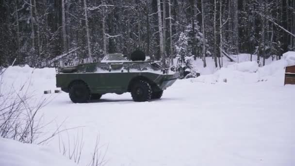 Portabagagli blindato in uno scenario invernale. Clip. Portiere militari corazzate nella foresta — Video Stock