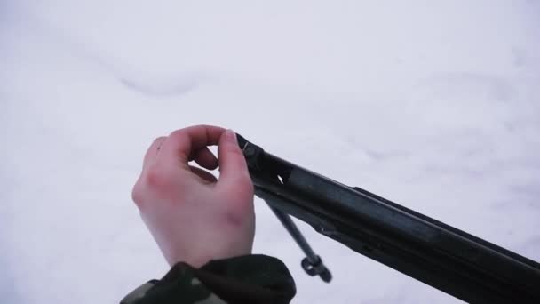 Armas para disparar galería en el bosque en invierno. Clip. Las manos recargan el arma para el campo de tiro al aire libre — Vídeo de stock