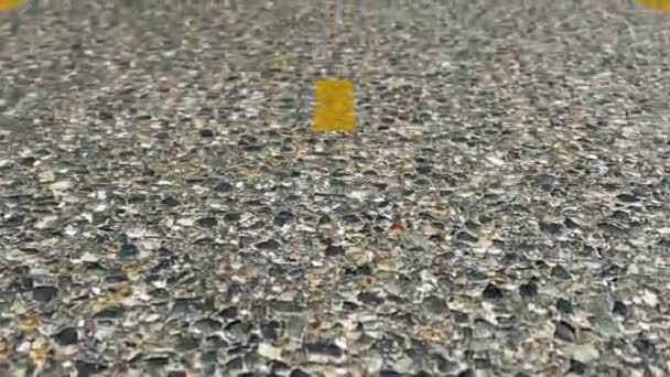 Nahsicht auf eine asphaltierte Straße mit Markierungsstreifen. Nahaufnahme-Animation von Asphalt — Stockvideo