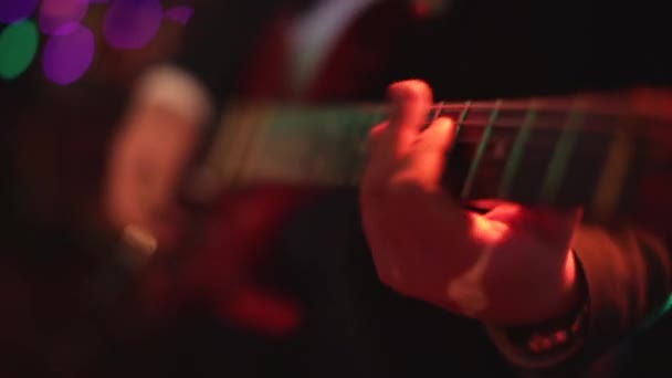 Chitarra elettrica. Azioni. Chitarra grigio-nera. Musicista suona musica rock. Il gioco energetico dello stile rock. Fondo nero. Assolo veloce di chitarra. Sei corde. Tira le corde. mediatore di gioco. Rock and roll — Video Stock