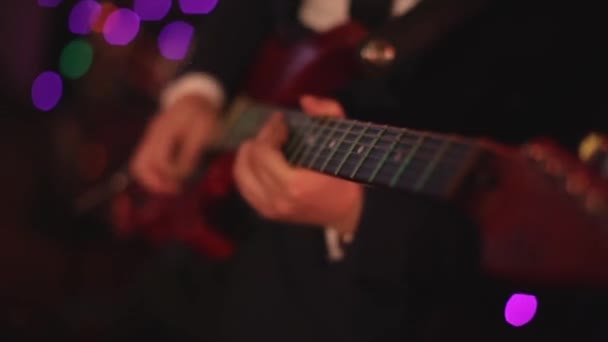 Chitarra elettrica. Azioni. Chitarra grigio-nera. Musicista suona musica rock. Il gioco energetico dello stile rock. Fondo nero. Assolo veloce di chitarra. Sei corde. Tira le corde. mediatore di gioco. Rock and roll — Video Stock