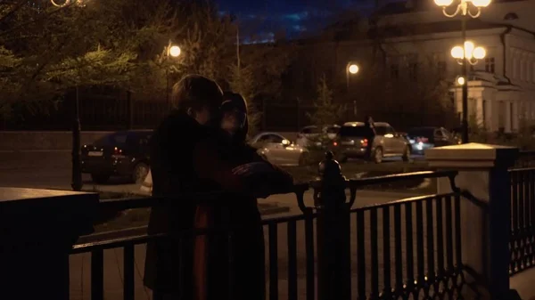 Pareja joven mirando en la hermosa ciudad detrás de un paisaje urbano estancia en un muelle de un río — Foto de Stock