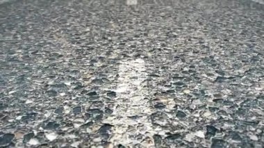 Bir asfalt yol işaretleme ile yakın çekim dokusuna. Asfalt yol üzerinde beyaz çizgi kapatın. yumuşak odak. Satırları işaretleme ile yol asfalt ve lastik izleri. Seçici odak ile fotoğraf kapatmak