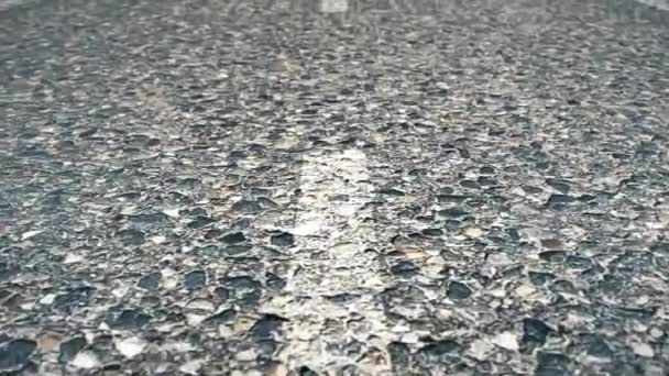 Nahaufnahme einer asphaltierten Straße mit Markierung. weiße Linie auf Asphaltstraße aus nächster Nähe. Weichzeichner. Asphaltstraße mit Markierungslinien und Reifenspuren. Nahaufnahme-Foto mit selektivem Fokus — Stockvideo