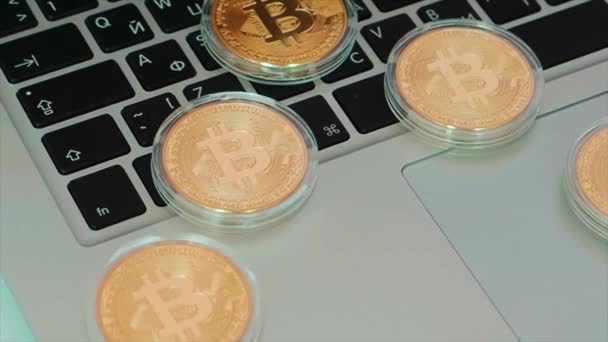 Bitcoin na klávesnici pro laptop. V UK. Bitcoin mince zblízka s notebookem v pozadí, kryptoměn koncept. Bitcoin zlaté mince s notebooku klávesnice, detail. Virtuální kryptoměn koncept. — Stock video