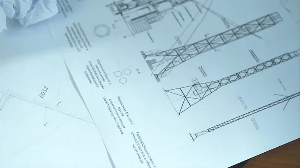 Vista aérea del escritorio de arquitectos con planos y computadora. Acciones. Vista superior de un escritorio de trabajo: ordenador portátil, gafas, teléfono móvil, pluma, dibujo del arquitecto, primer plano —  Fotos de Stock