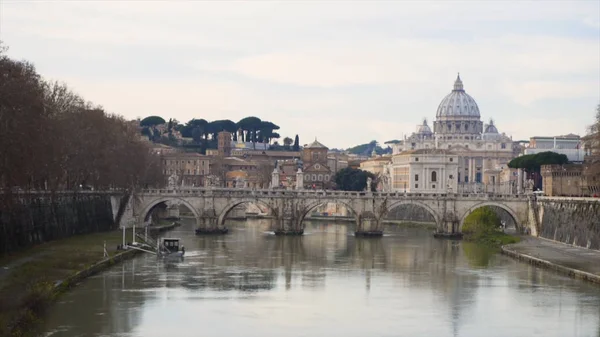 Ponte coperto su un fiume con una chiesa sullo sfondo. Azioni. Paesaggio urbano europeo con sfondo fluviale, ponte e chiesa. Vista panoramica sulle rive del fiume Isere e sul ponte . — Foto Stock