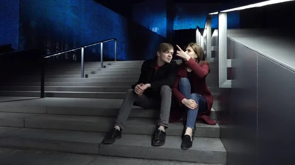 Jeune couple assis dans les escaliers la nuit. Belle nuit pour une promenade dans la ville — Photo