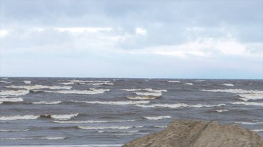 Köpüklü dalgalar fırtına sırasında. Yağmurlu bir gün. Video. Deniz fırtınası. Dalgalar bir çakıl taş Plajı üzerinde haddeleme. Ağır çekim. Deniz suyu. dalga. bir fırtına uyarısı.