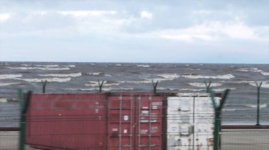 Köpüklü dalgalar fırtına sırasında. Yağmurlu bir gün. Video. Deniz fırtınası. Dalgalar bir çakıl taş Plajı üzerinde haddeleme. Ağır çekim. Deniz suyu. dalga. bir fırtına uyarısı.