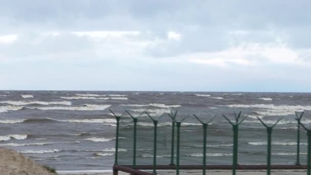 Ondas espumosas durante una tormenta. Un día lluvioso. Vídeo. Tormenta en el mar. Las olas están rodando en una playa de guijarros. A cámara lenta. Agua de mar. Saluda. una advertencia de tormenta . — Vídeo de stock