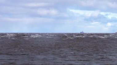 Bir fırtına sırasında denizde tanker gemisi. Bir bulutlu gökyüzü altında ufukta tanker kargo gemileri. Bir kargo gemisi ve denizin dalgaları ile fırtınalı gökyüzünde kara bulutlar. Video.