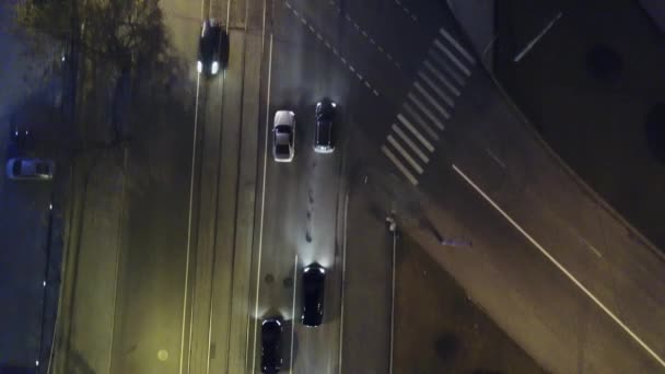 Het licht paden van de auto in de stad kruispunt, verkeer. Video. Top Down luchtfoto Drone zicht op een weg met auto's rijden, reflecterende koplampen 's nachts. Luchtfoto van de snelweg weg van de lege stad straat in — Stockvideo