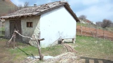 Panoramik manzaralı köy. Eski bir tek katlı ev, bir iyi ve bir tepe ile siyah ahşap tekne harap. Eski ahşap su iyi. Video